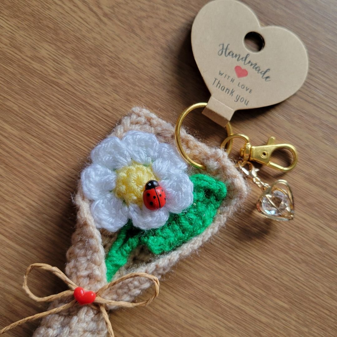 Crochet daisy keyring wrapped as mini bouquet with ladybug and crystal heart charm
