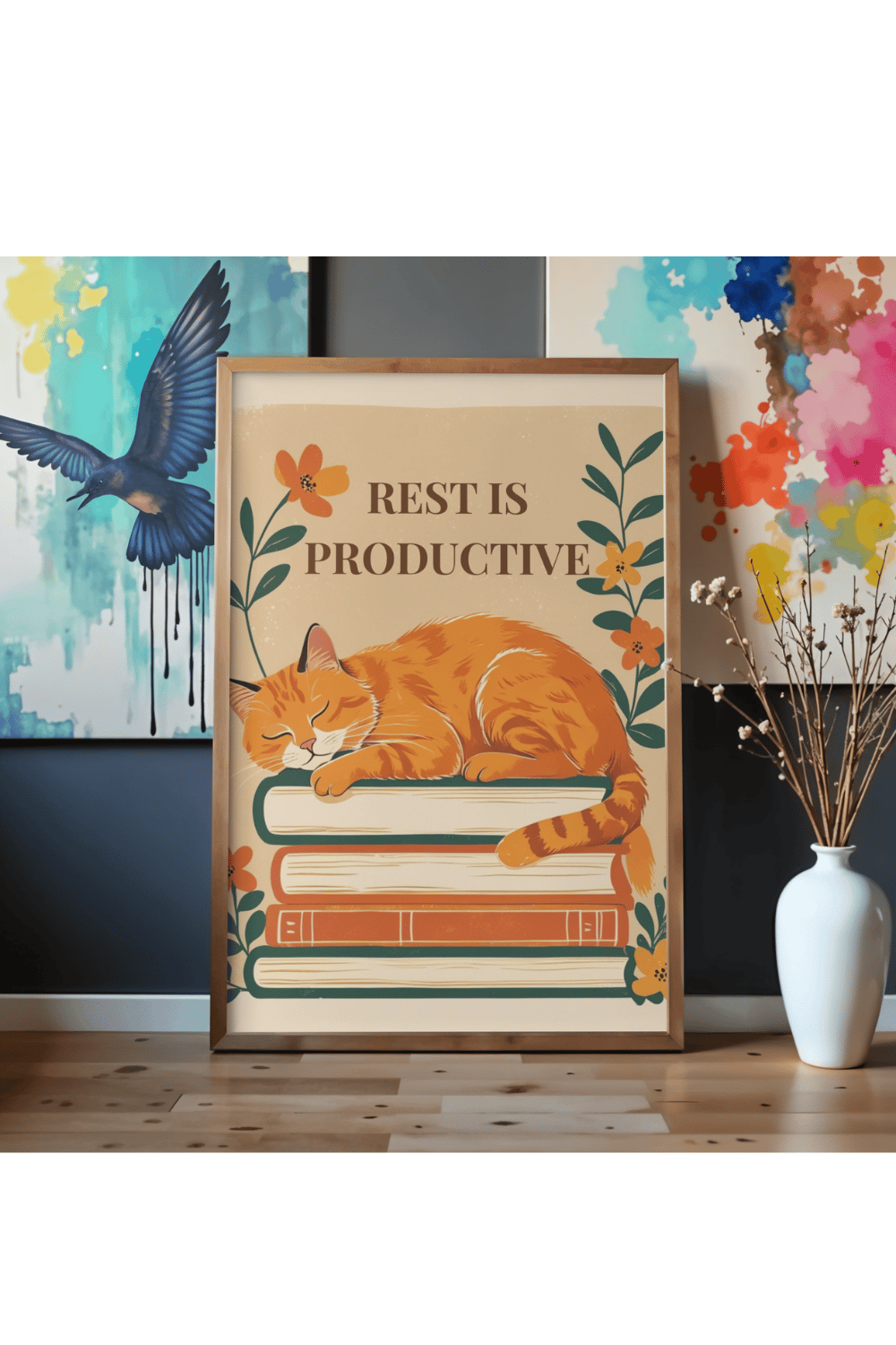 Rest is productive cat print displayed in wooden frame on desk as part of gallery wall with colorful blue abstract bird painting and pink splash art - printable poster for eclectic home decor