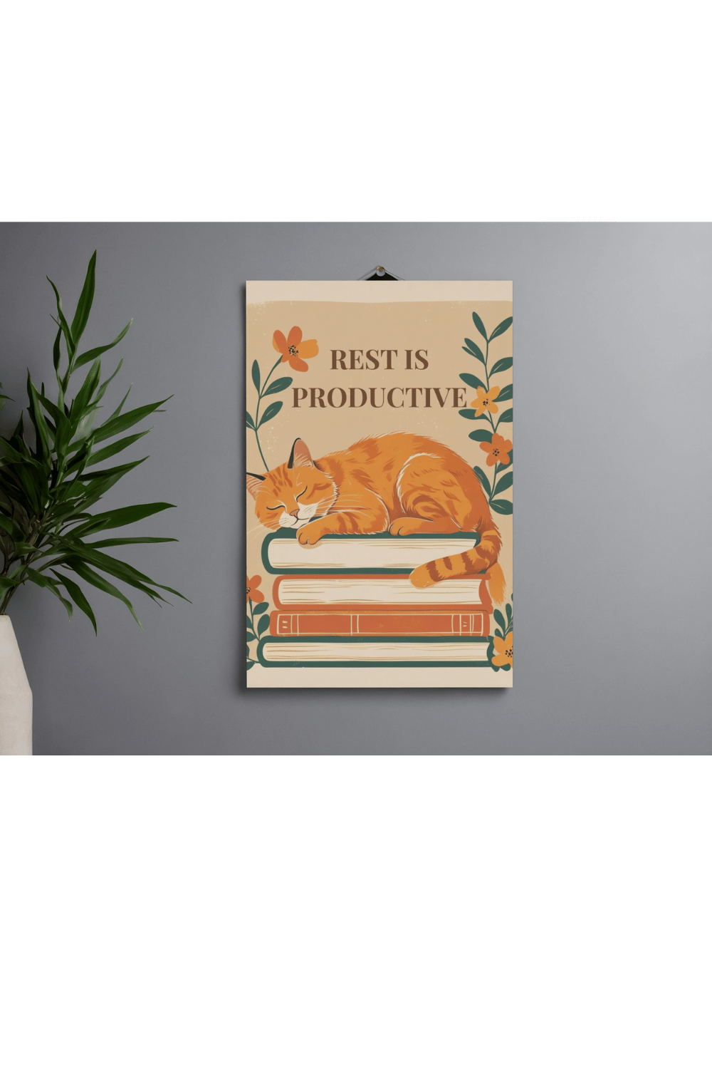 Minimalist cat wall art print on gray wall next to green potted plant showing orange tabby on books with botanical flowers - printable rest is productive poster for calm spaces