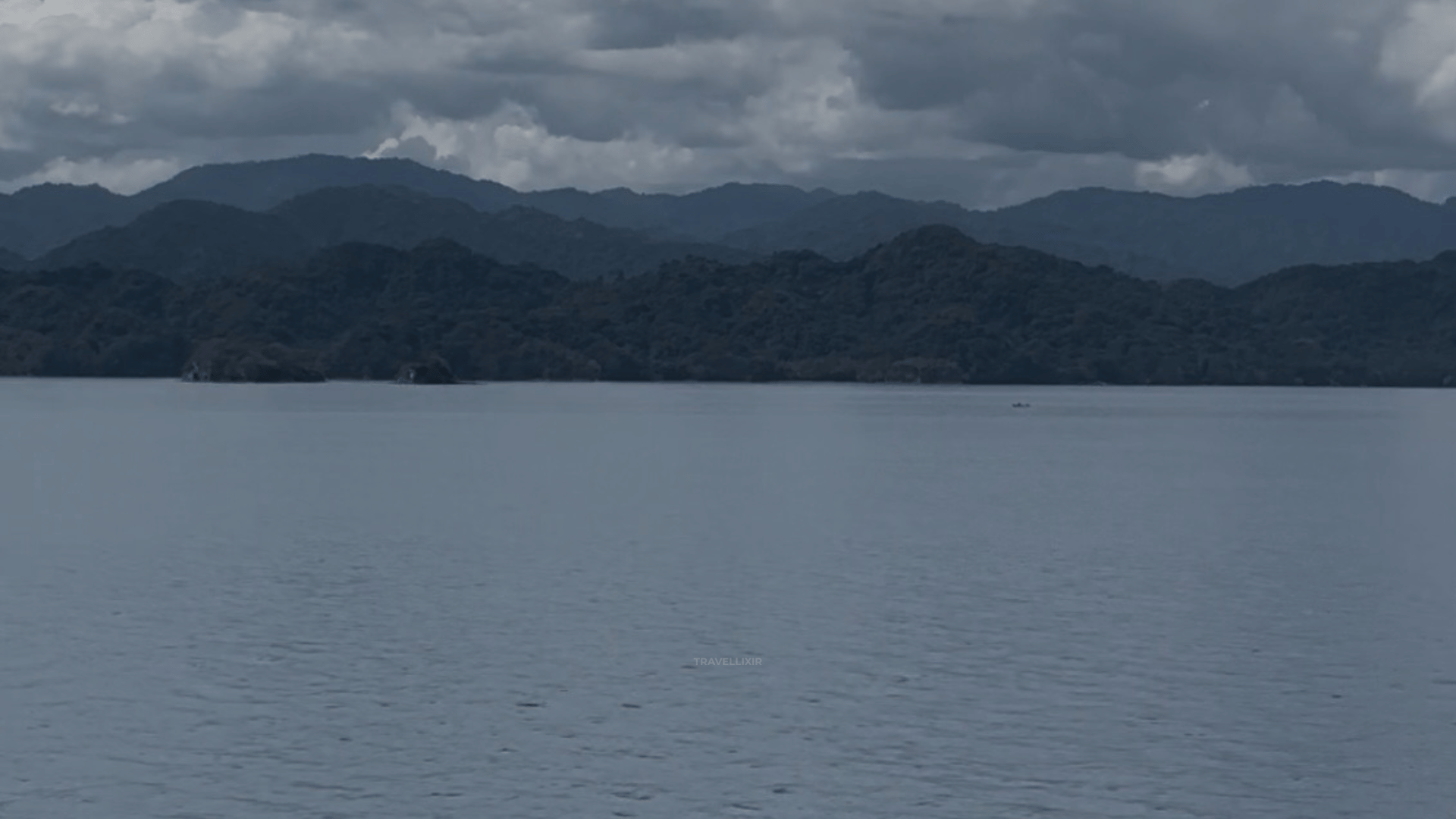 Misty mountain landscape over calm water symbolizing strategic global travel and clarity.