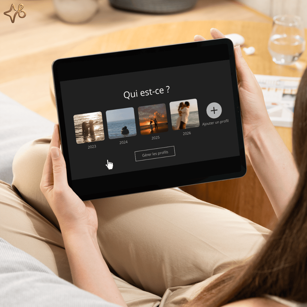 Vue de dessus dune personne tenant une tablette affichant lécran de sélection des profils personnalisés avec des photos de couple pour la vidéo cadeau.