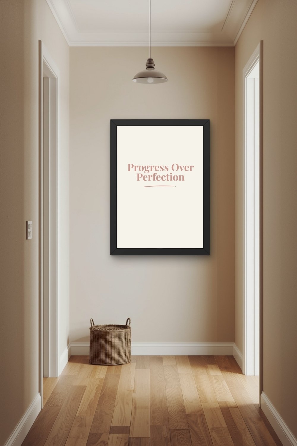 A terracotta typographic wall art print in a wooden frame leaning against a neutral wall on a wooden shelf beside a trailing pothos in a terracotta pot, a small candle, and a stack of books.