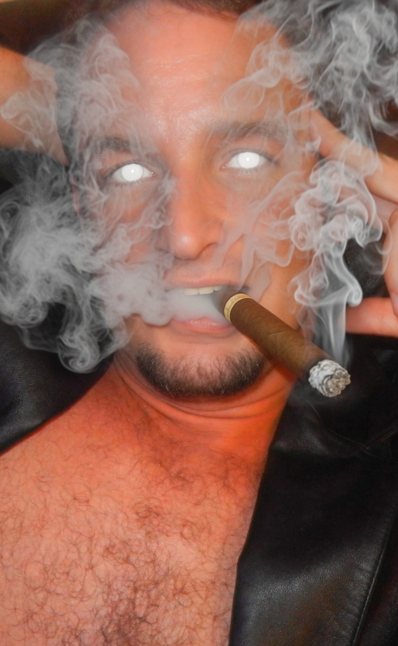 Handsome cigar smoking man with hypnotic blank eyes wearing leather blazer shirtless