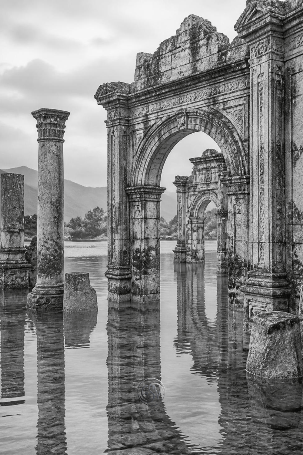 Grayscale coloring page of an ancient temple ruin half-submerged  in still lake water with reflections of broken columns