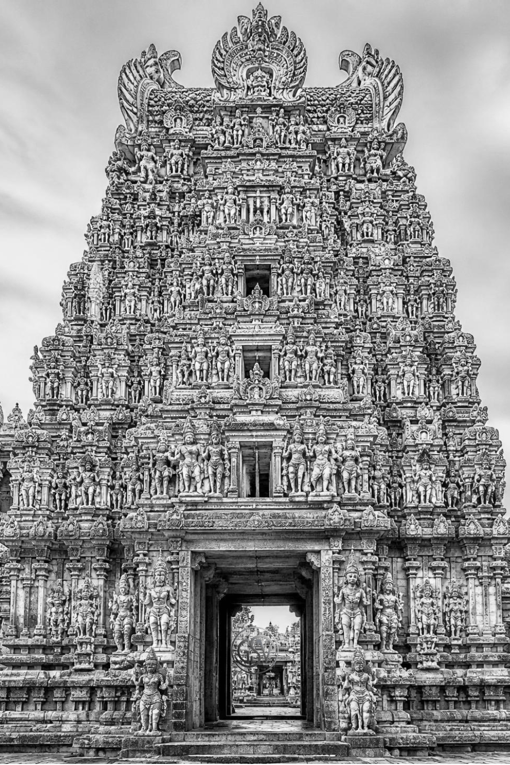 Grayscale coloring page of an intricately carved Hindu temple tower  covered in weathered stone sculptures
