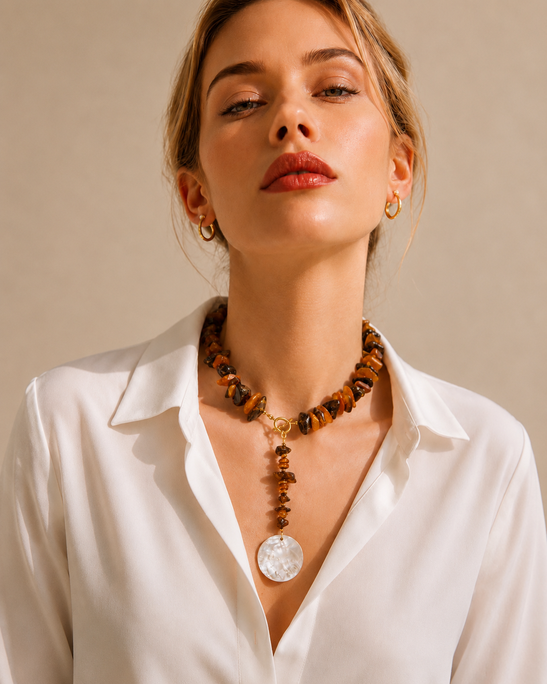 Modella che indossa collana in ambra baltica naturale grezza con ciondolo in madreperla naturale, gioiello artigianale Lumen Jewels