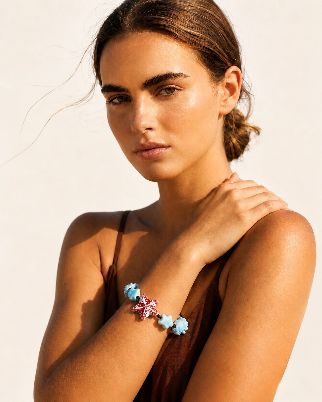 Modella che indossa il bracciale artigianale ispirato al mare, fotografia lifestyle con luce naturale.