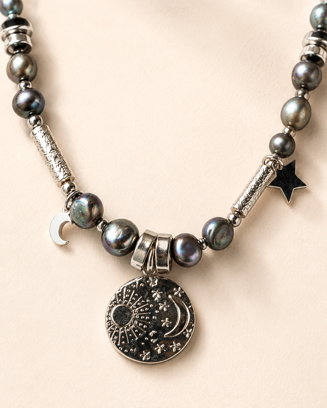Dettaglio delle perle d’acqua dolce, dell’ematite e della medaglietta in acciaio inox.