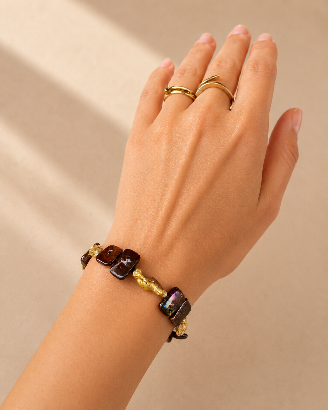 Dettaglio del bracciale indossato al polso con perle naturali e chiusura a cuore.