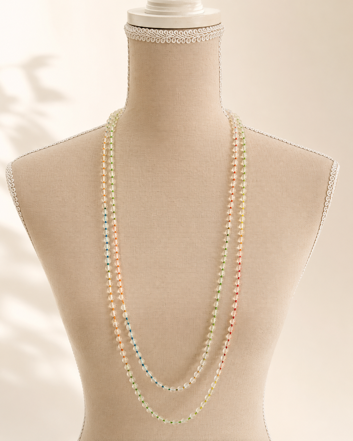 Collana lunga artigianale in pietra di luna naturale da 4 mm esposta su busto.