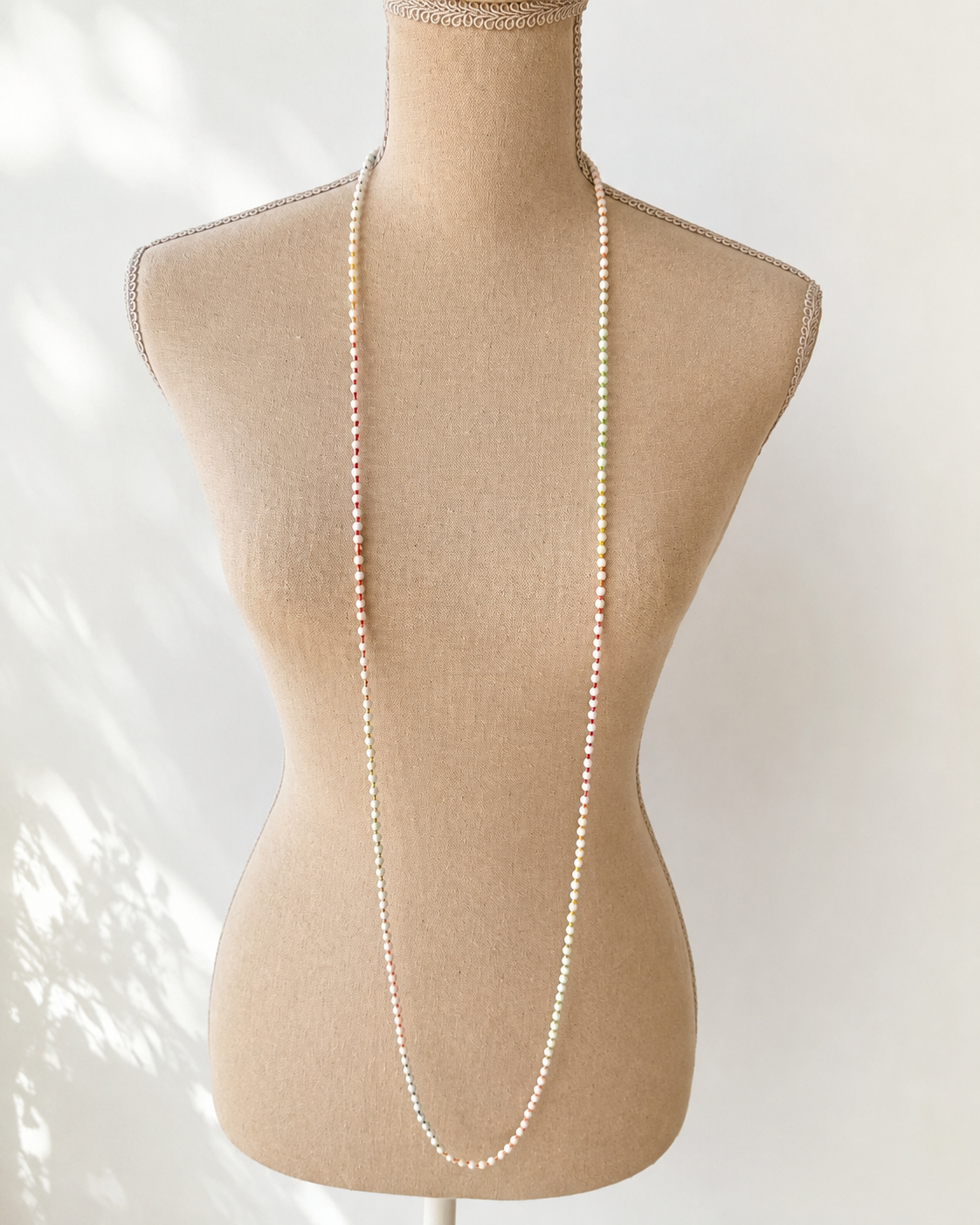 Collana lunga in agata bianca naturale da 3 mm esposta su manichino.