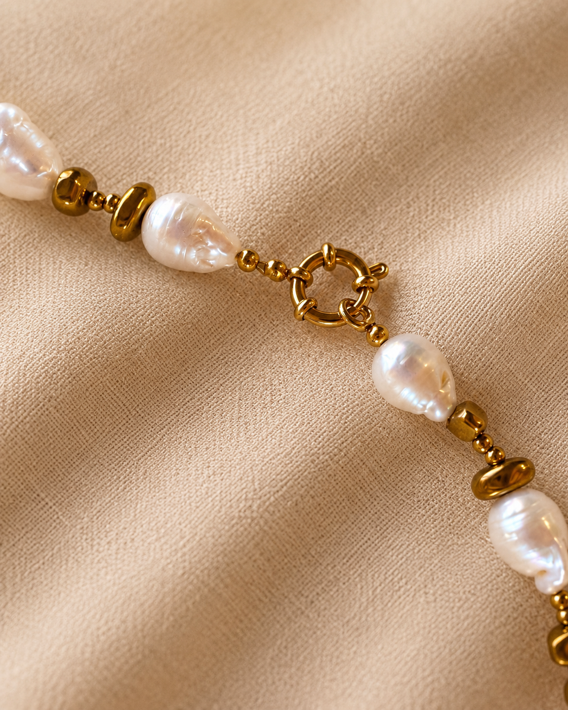 Dettaglio della collana Lumen Jewels con perle barocche, ematite color oro e acciaio inox.