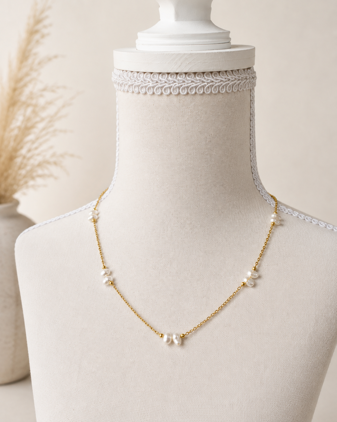 Collana minimal in acciaio color oro con perle di fiume naturali su manichino.