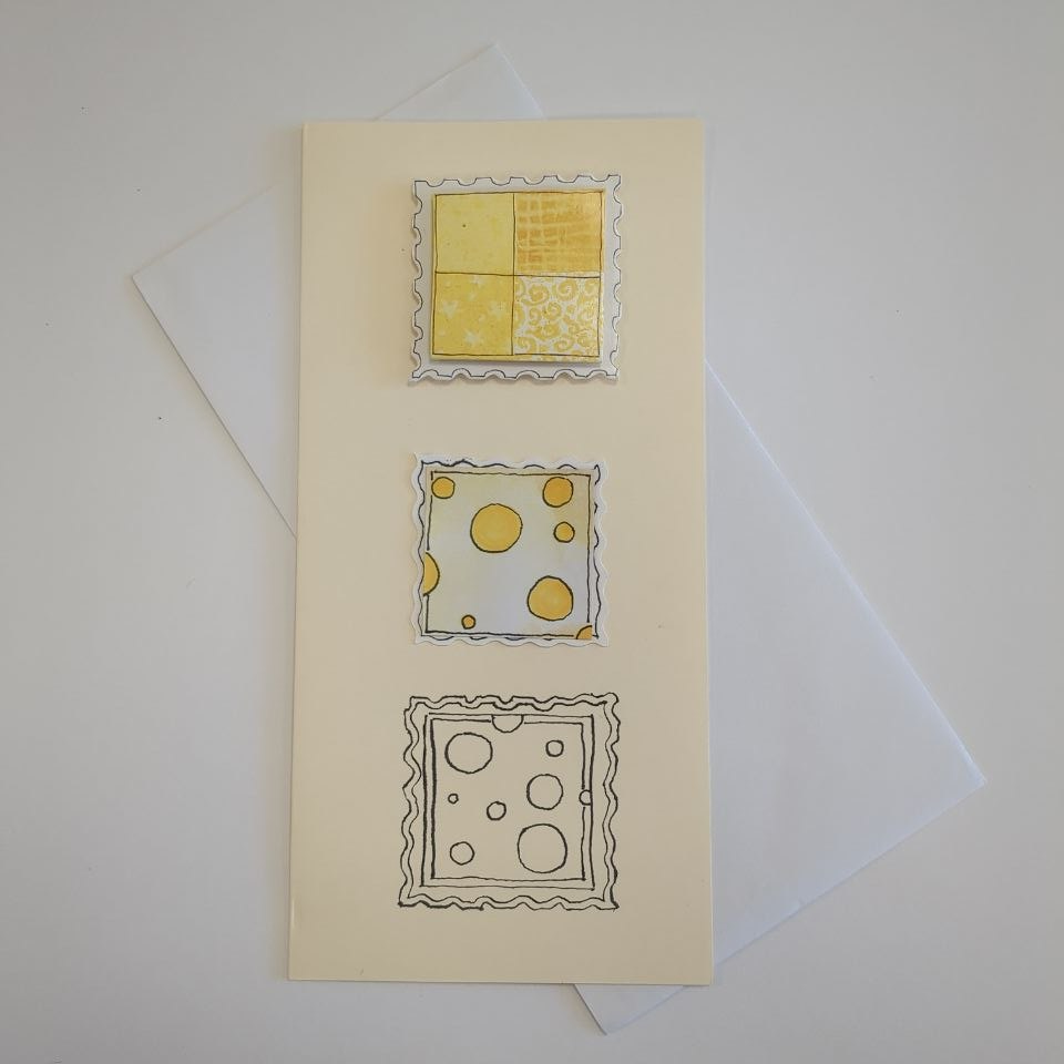 A tall portrait card in cream with a white envelope. Three squares with postage stamp effect edges are centred down the middle of the card. The top one is raised and features a yellow quartered pattern on a white background. The middle one is less raised