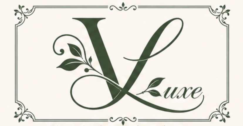 VLuxe Wellness logo featuring an elegant dark-green letter V with botanical accents and a decorative border on a cream background.