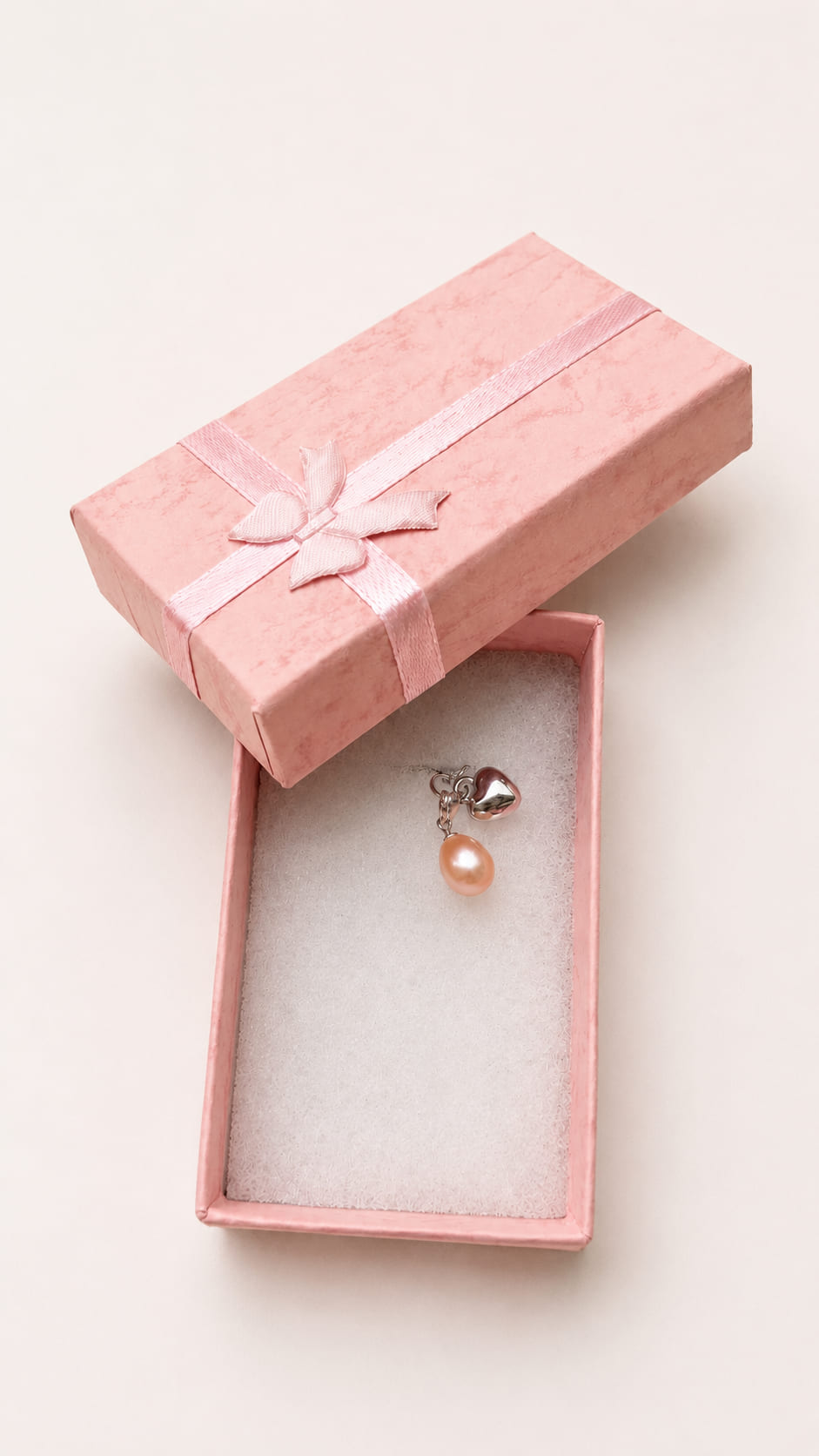 Handmade 925 sterling silver bridal bouquet memory charm featuring a dangling peach freshwater pearl and a polished silver heart charm inside an open pink gift box.