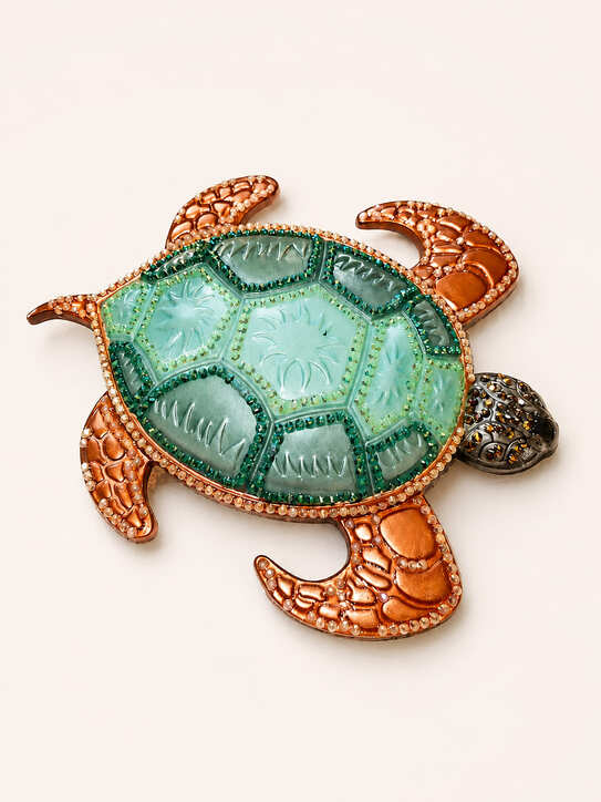 Top view of decorative resin sea turtle ornament with mint green shell and bronze-orange flippers