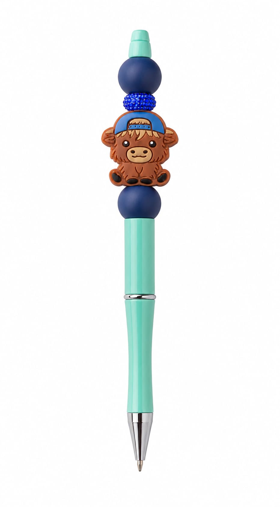 A teal custom ballpoint pen topped with a backward baseball cap Highland cow silicone charm, a glittering royal blue rhinestone spacer, and navy beads.