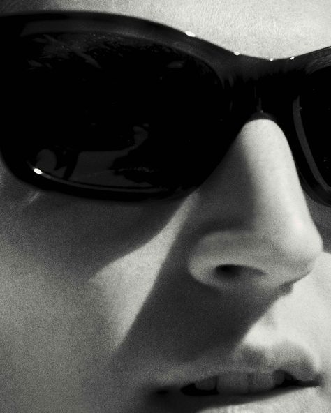 Close-up of black sunglasses on a woman in black and white, minimalist fashion photography. readthekut