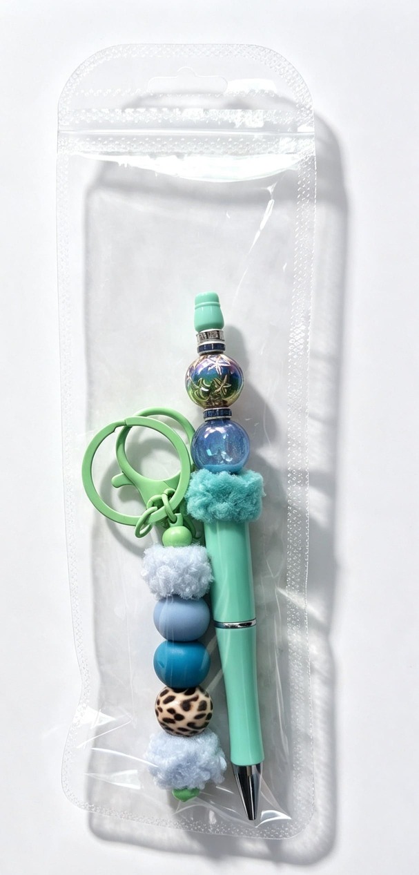 The Mint and Teal Cheetah Duo matching pen and keychain set from Sparkling Resin Delights, presented inside a clear retail cello presentation bag with a hang hole.