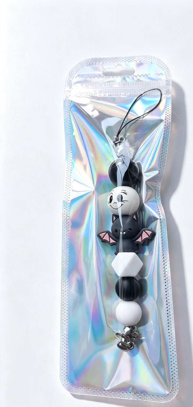 Handmade pastel bat beaded phone charm presented in a shimmering holographic resealable gift pouch
