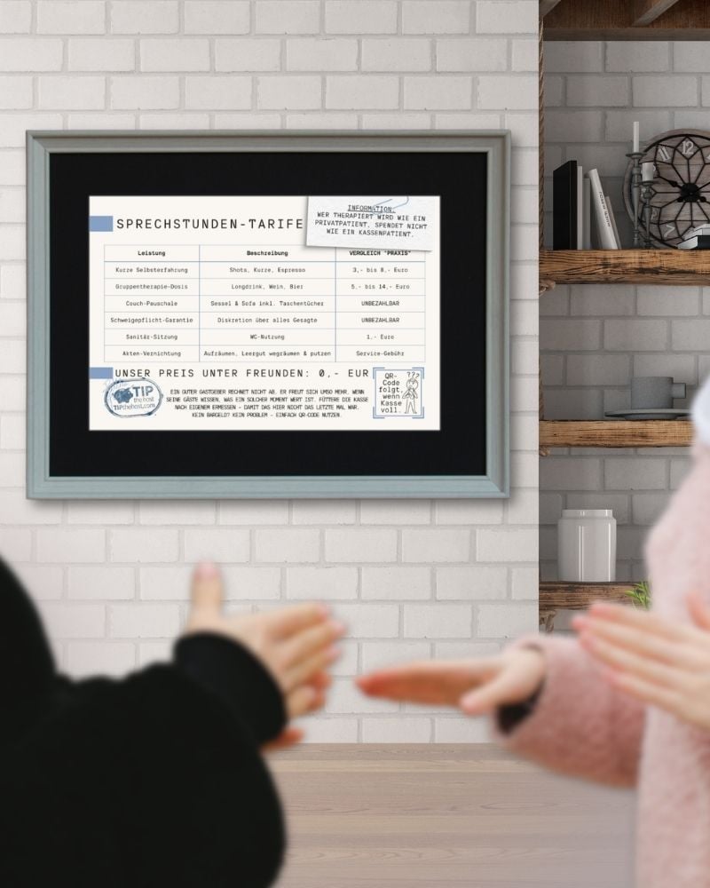 Gerahmte Preisliste in der hellen Variante an einer Ziegelwand über dem Küchentisch, zwei Personen im Gespräch davor