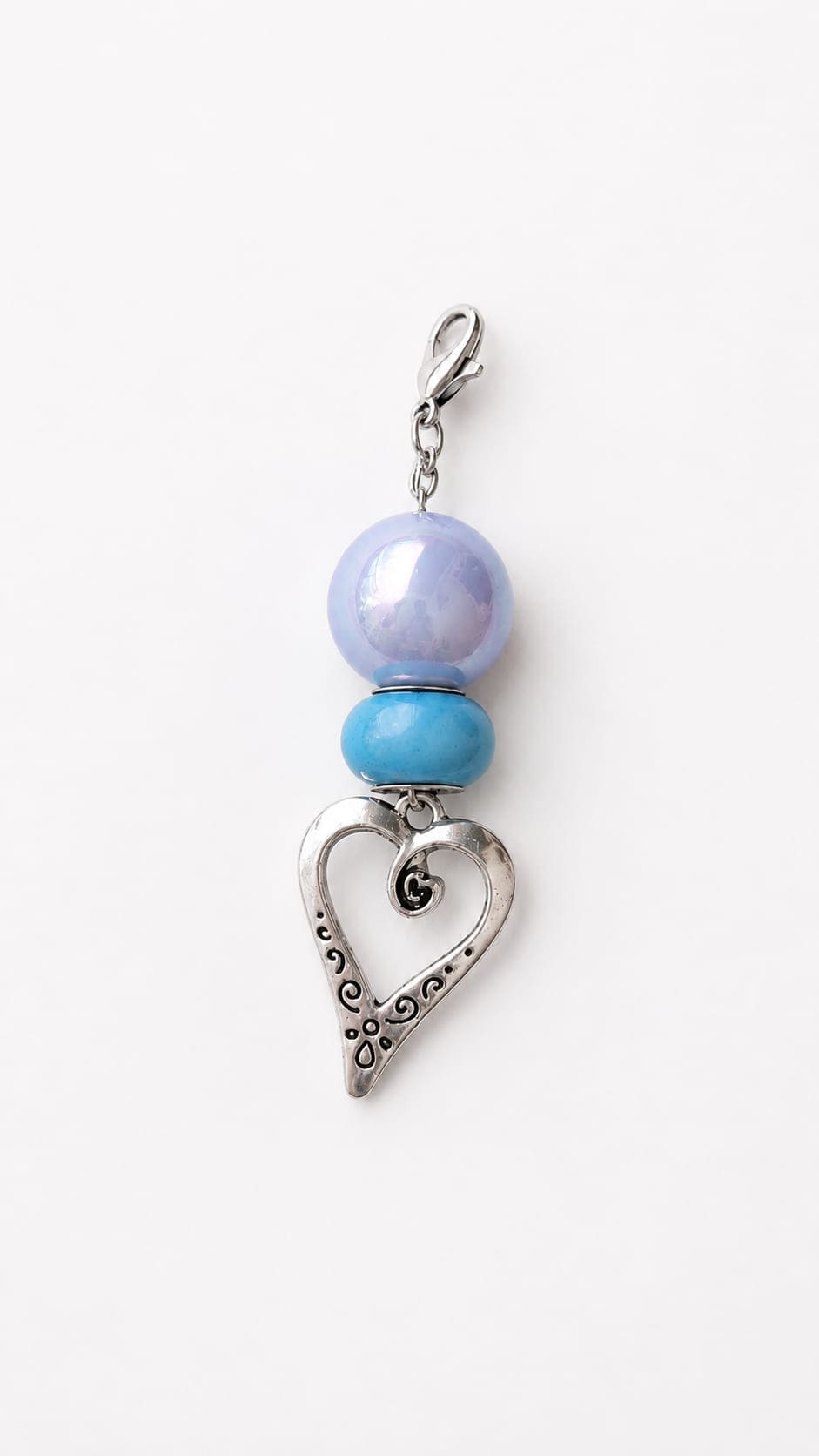 Handmade Something Blue bridal charm showcasing a high-shimmer lavender-purple pearlescent acrylic globe stacked above a smooth, rich turquoise spacer bead. The vertical design suspends from a silver lobster clasp and features a dangling antique silver fi