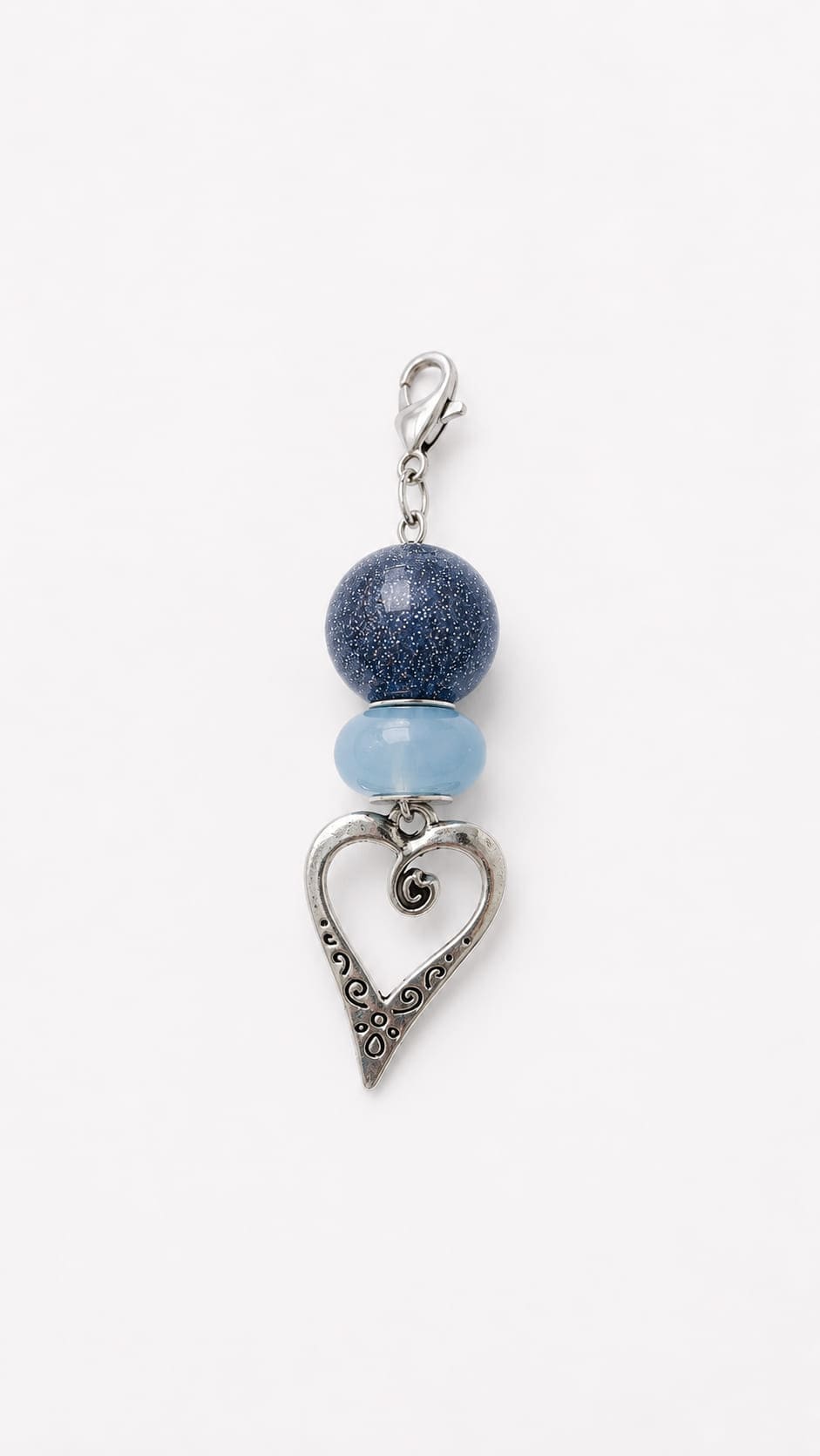 Handmade wedding keepsake charm showcasing a dark midnight shimmer glitter bead, an ice blue matte accent bead, and a detailed vintage-style silver heart pendant.