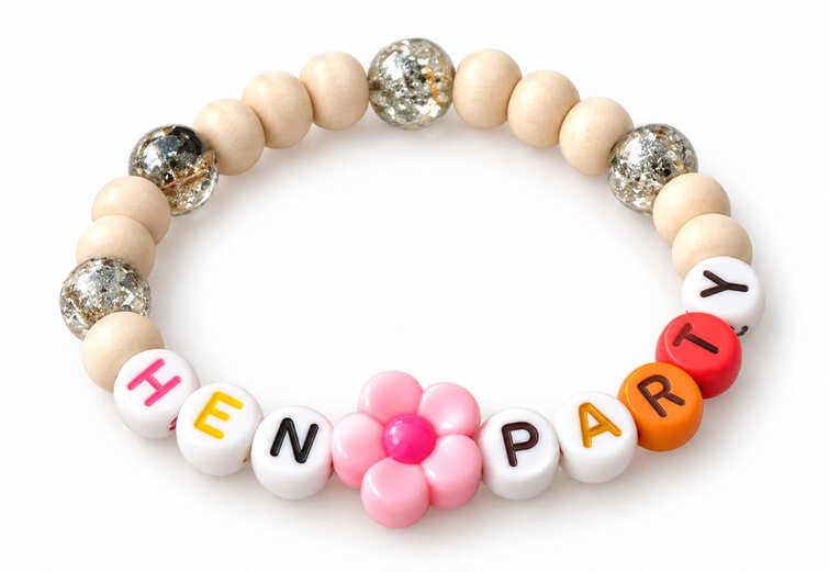 A rustic Hen Party friendship bracelet crafted with smooth natural wood beads, silver foil clear resin beads, and a pastel pink flower charm.