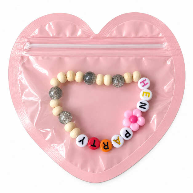 Rustic Hen Party friendship bracelet featuring natural wood beads, crackled grey glass beads, and a pink resin flower charm in heart packaging.