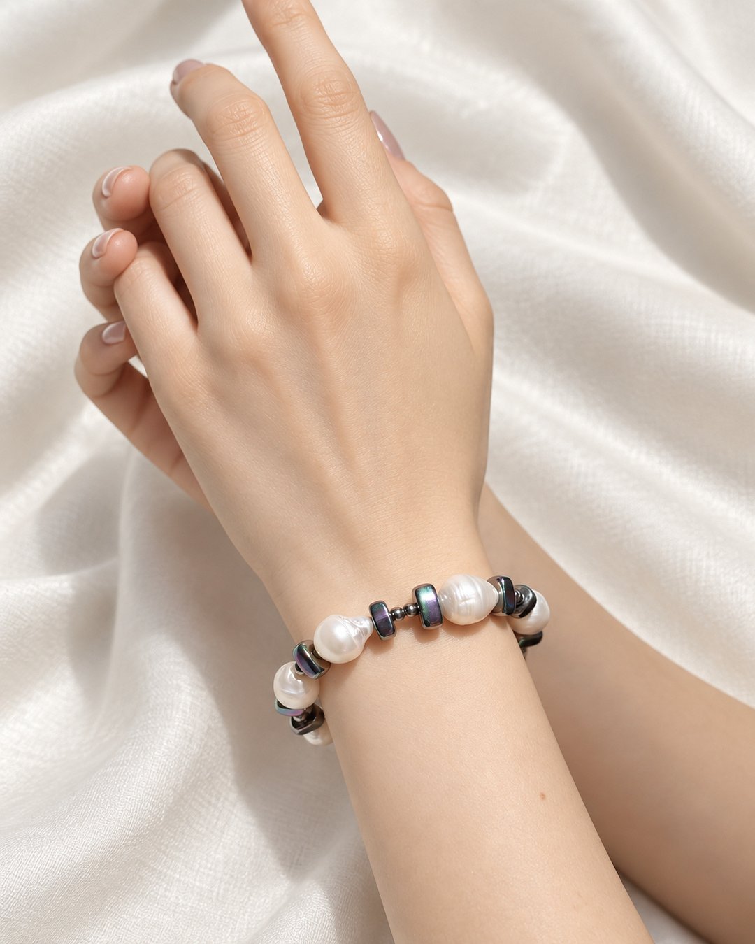 Bracciale artigianale con perle di fiume indossato al polso