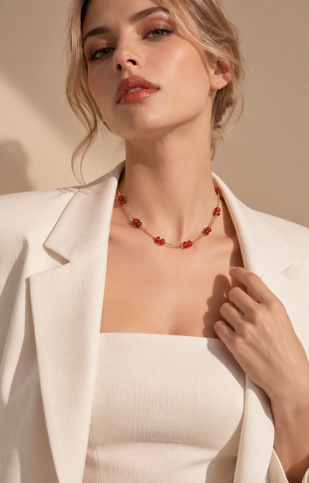 Collana minimal dorata con granato arancione abbinata a un look elegante
