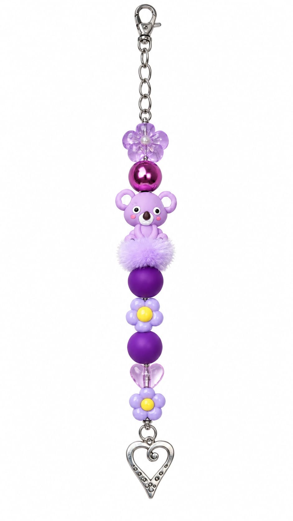 A close-up view of a novelty purple animal-themed fidget strap showing a silver lobster clasp, a clear purple flower bead, a shiny metallic magenta ball, a smiling cartoon purple koala bead, a fluffy lavender pom-pom, yellow-centered purple blossoms, matt