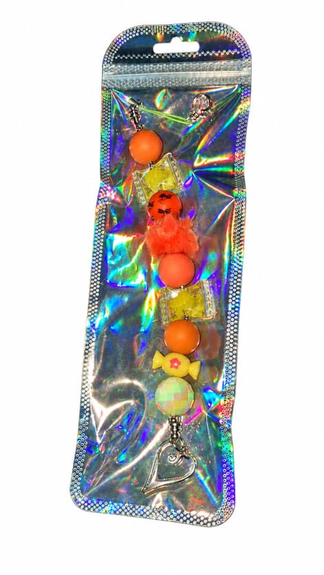 A vibrant neon orange and yellow candy silicone beaded fidget charm displayed inside a glossy, iridescent holographic retail pouch.