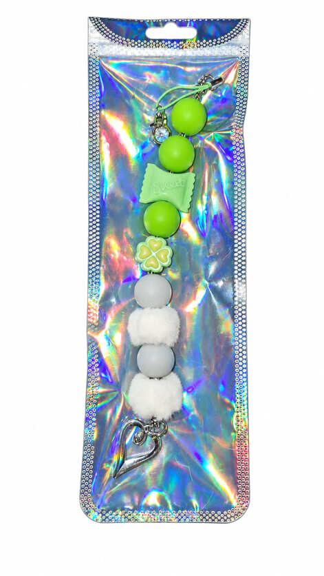 A crisp mint green clover and white pom-pom silicone beaded fidget charm with a crystal accent, displayed inside a glossy, iridescent holographic retail pouch.