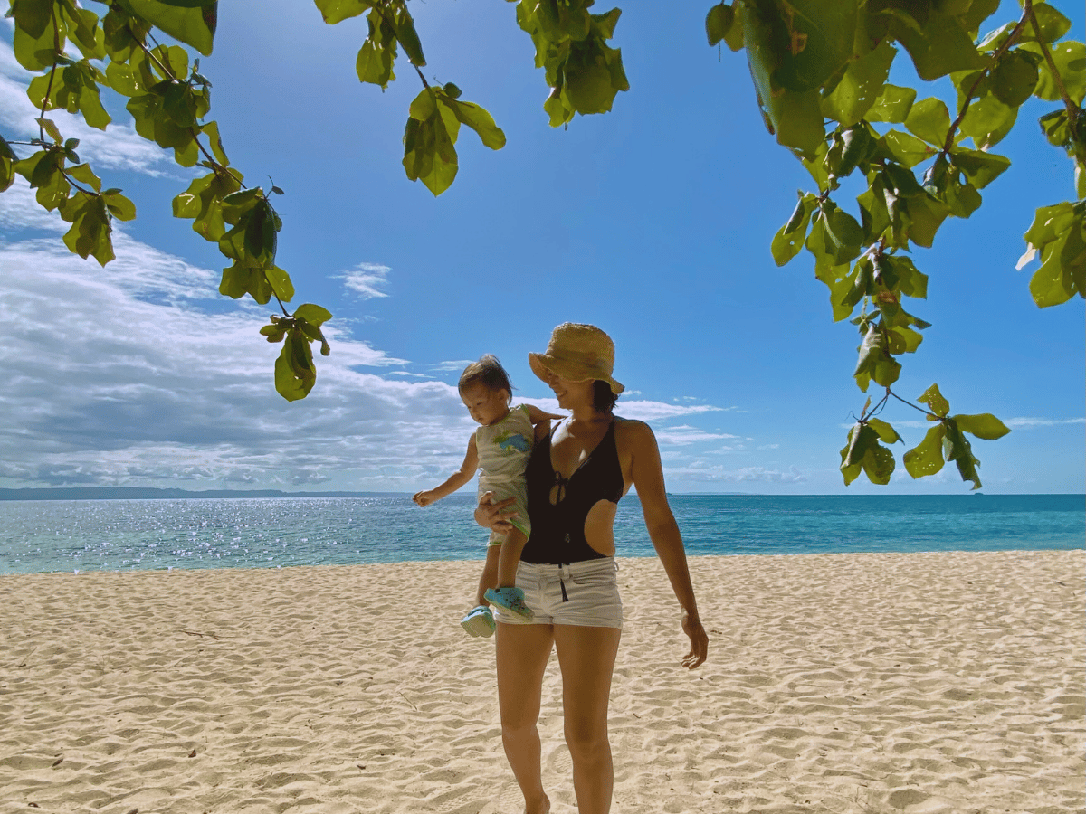 A mom carrying her toddler on a white sand beach feeling like she's More Than Just A Mom