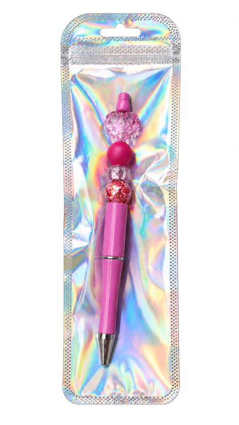 A custom hot pink beaded pen with a faceted heart topper displayed inside a long, shimmering, iridescent holographic retail pouch.