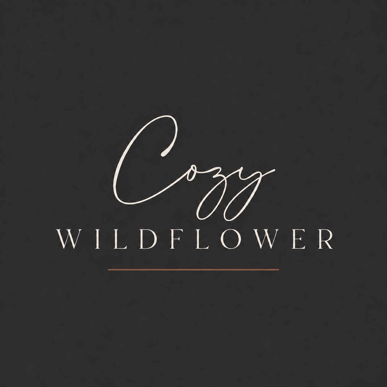 A square logo with a soft charcoal-black background. “Cozy” appears in elegant cream handwritten script above “WILDFLOWER” in widely spaced uppercase lettering, finished with a thin warm-brown line underneath. The overall look is cozy, modern and minimalist.