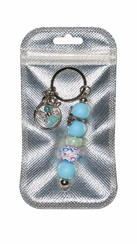 Handmade sky blue snake and angel bag charm presented in a shimmering silver gift pouch