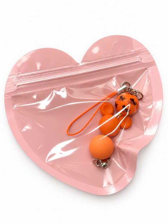 Whimsical orange bee and mouse-themed bridal party favour charm packaged inside a decorative resealable pink heart-shaped gift pouch.