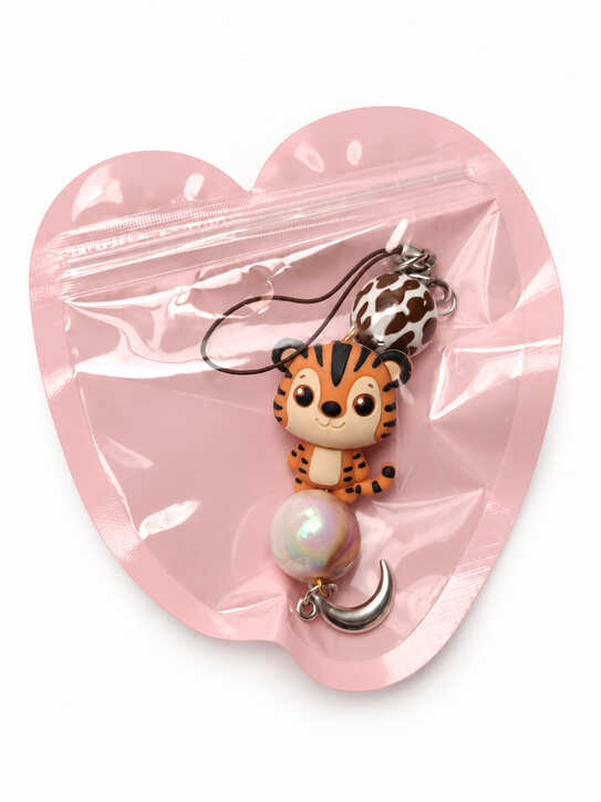 Whimsical baby tiger bridal party favour charm packaged inside a decorative resealable pink heart-shaped gift pouch.