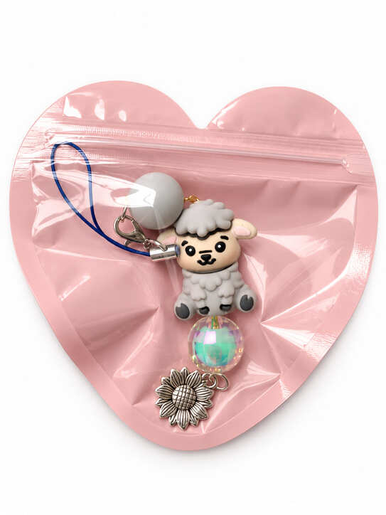 Cute grey baby lamb bridal party favour accessory packaged inside a decorative resealable pink heart-shaped gift pouch.