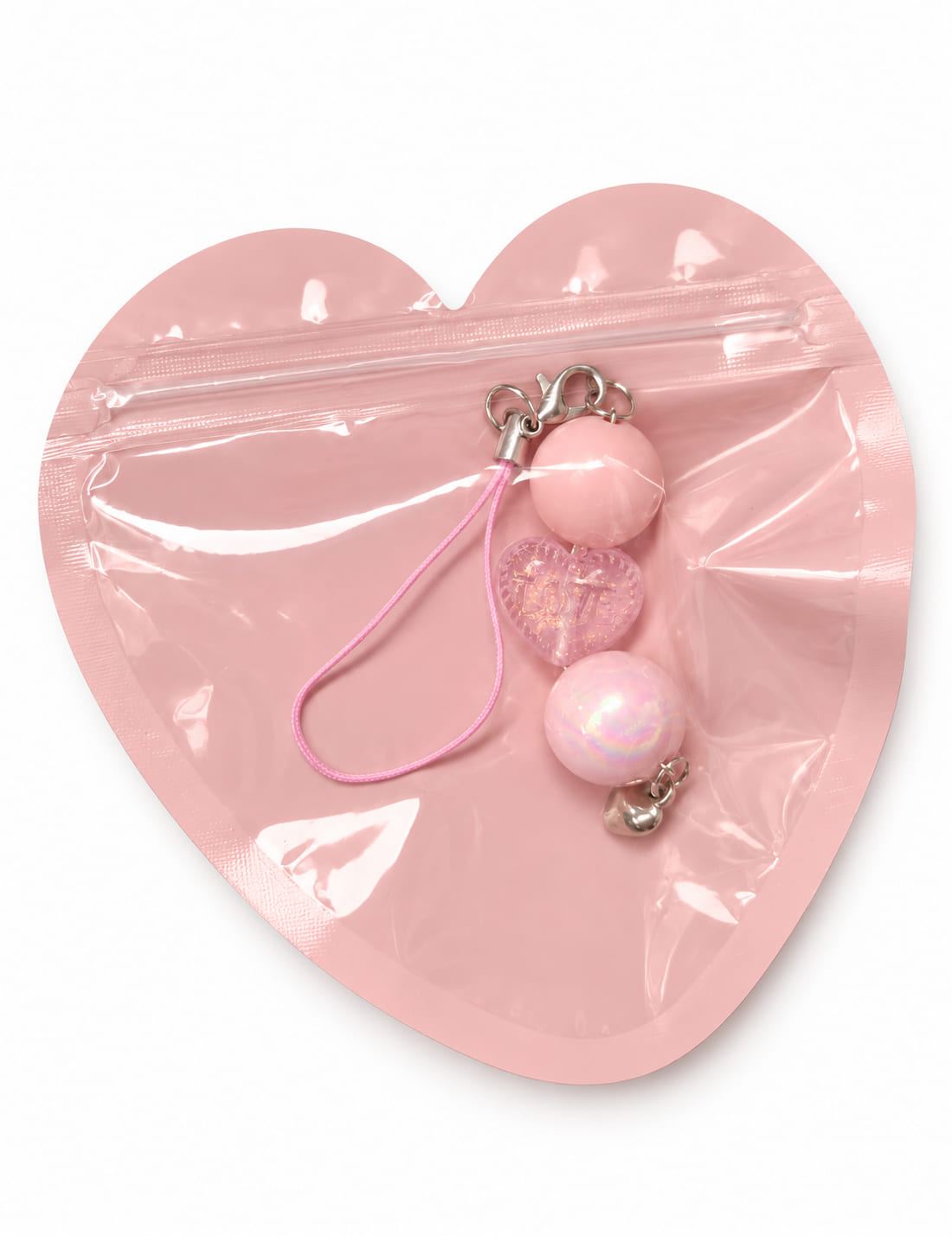 Blush iridescent heart charm tucked inside a matching pink heart-shaped bag, perfect for bridesmaid proposal boxes.