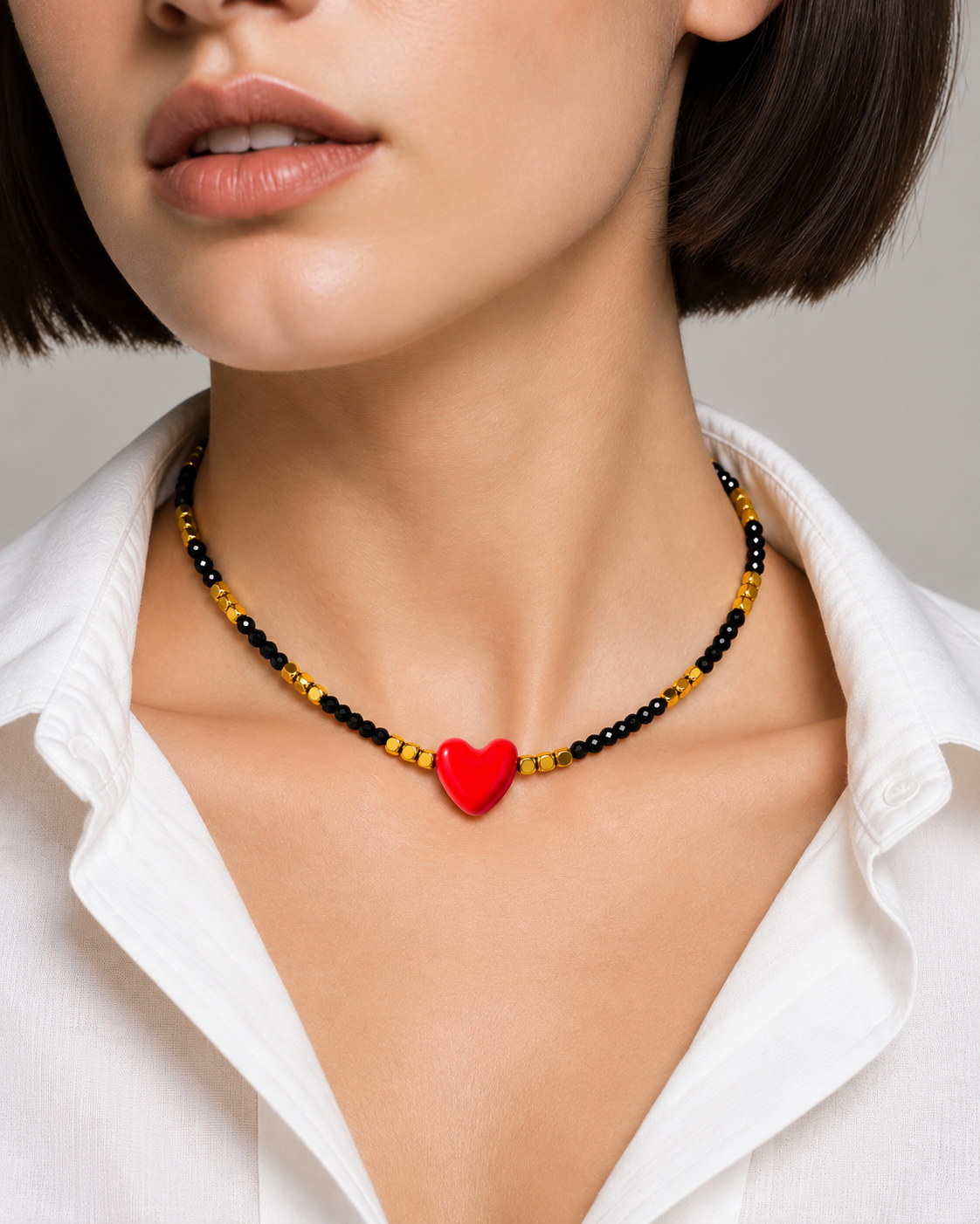 Collana artigianale con ossidiana nera e cuore rosso in ceramica indossata al collo