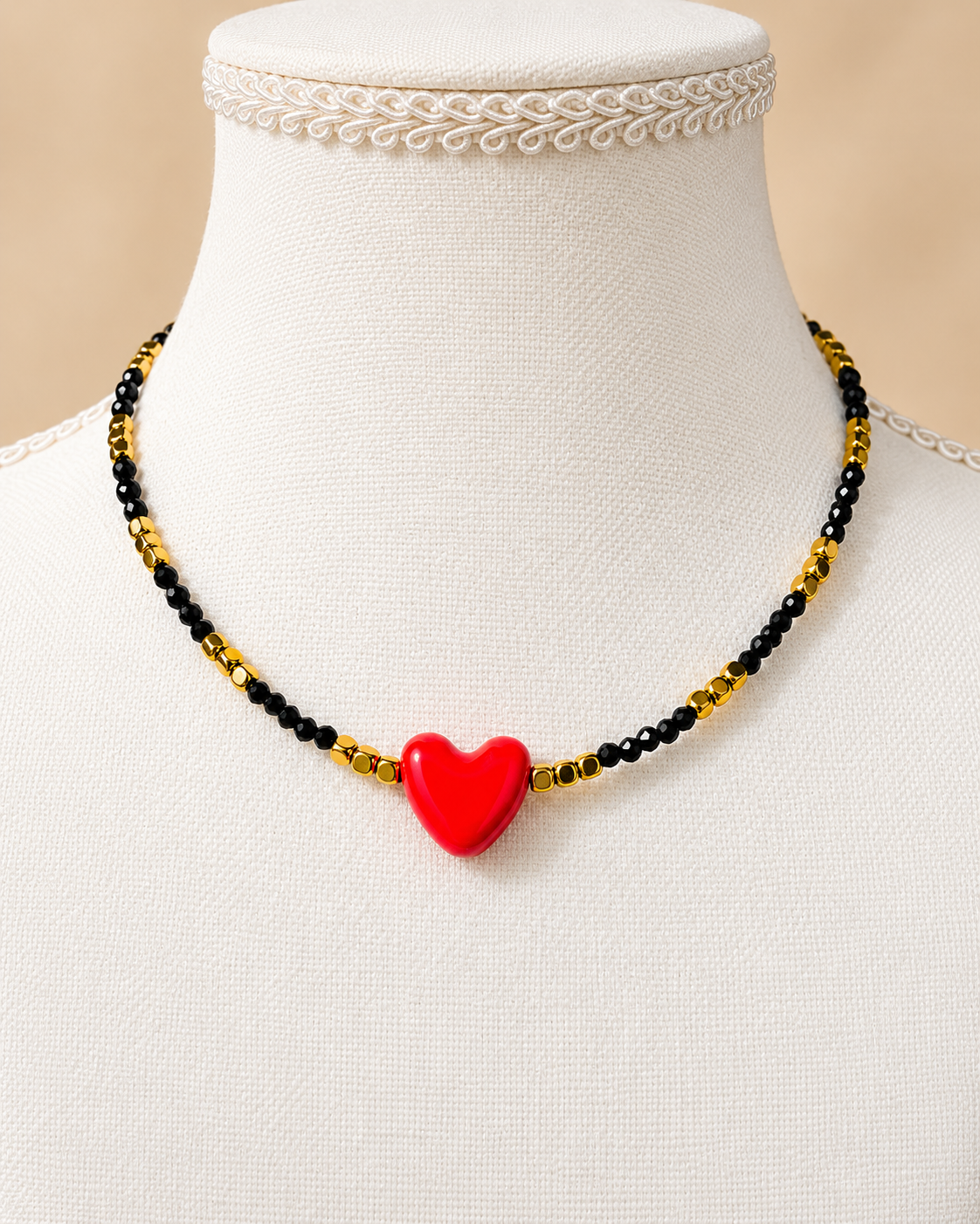 Collana Cuore Rosso in ossidiana nera e onice dorato su manichino bianco
