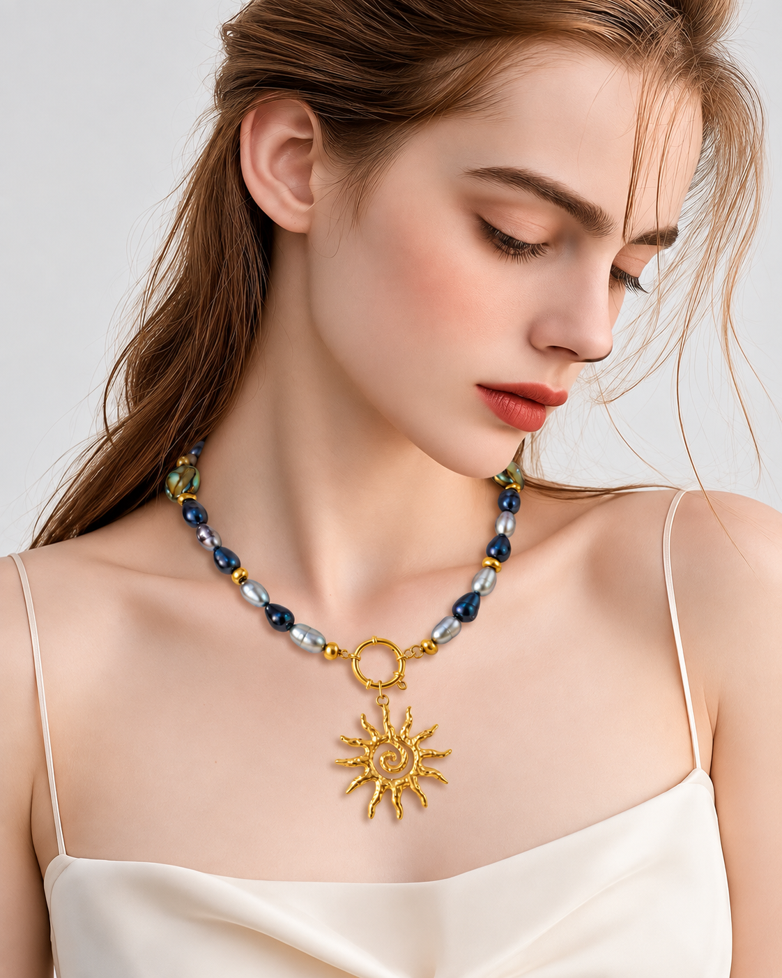 Collana artigianale Re Sole con perle grigie e ciondolo sole indossata