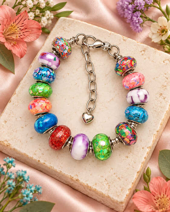 Rainbow Confetti European charm bracelet displayed on a stone slab