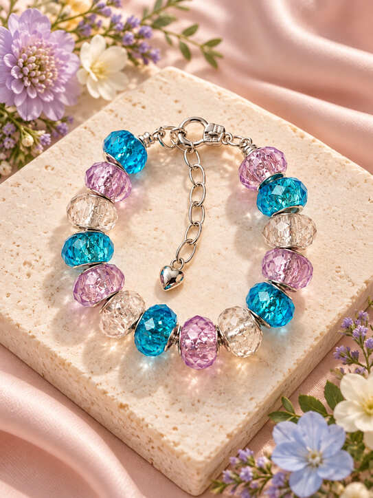 Blue and purple European charm bracelet displayed on a stone slab