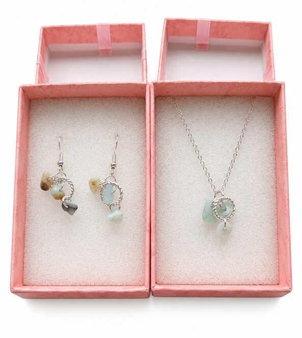 Matching sterling silver natural stone necklace and drop earrings presented in pink jewellery gift boxes