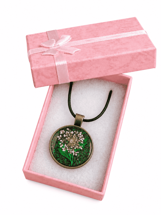 Handmade emerald green real flower resin necklace presented in a pink jewellery gift box